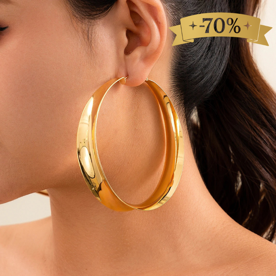Boucles d’oreilles créoles larges dorées en acier inoxydable portées par une femme – style audacieux et raffiné.