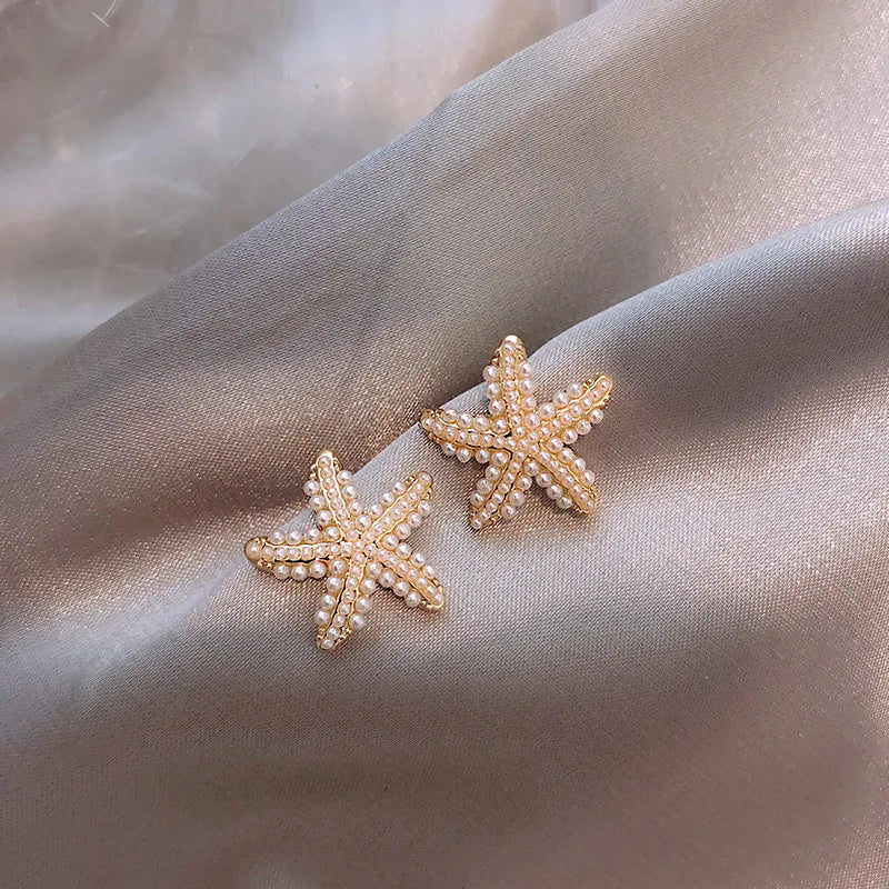 Boucles d’oreilles Nérée dorées en acier inoxydable, étoile de mer ornée de perles élégantes, bijou marin et sophistiqué.