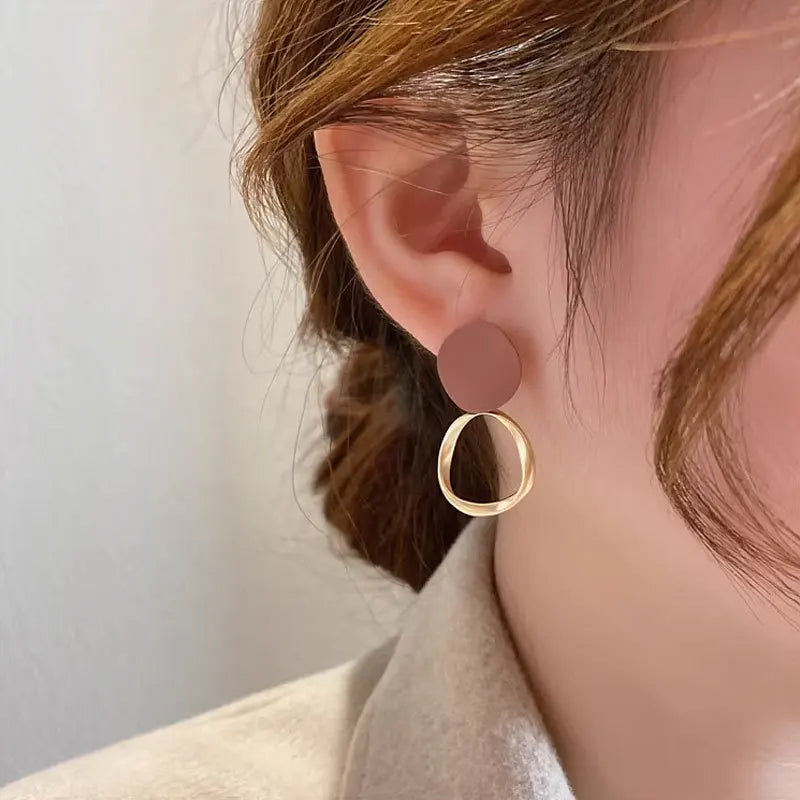 Boucles d’oreilles Théia en acier inoxydable doré avec détail marron profond, design pendants raffinés et élégants.