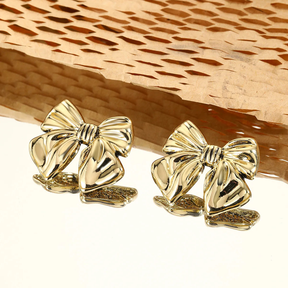 Boucles d’oreilles Lysimache en acier inoxydable doré, bijou lumineux et moderne captant la lumière avec éclat.
