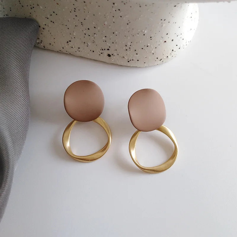 Boucles d’oreilles Théia en acier inoxydable doré avec détail marron, au design élégant et intemporel.