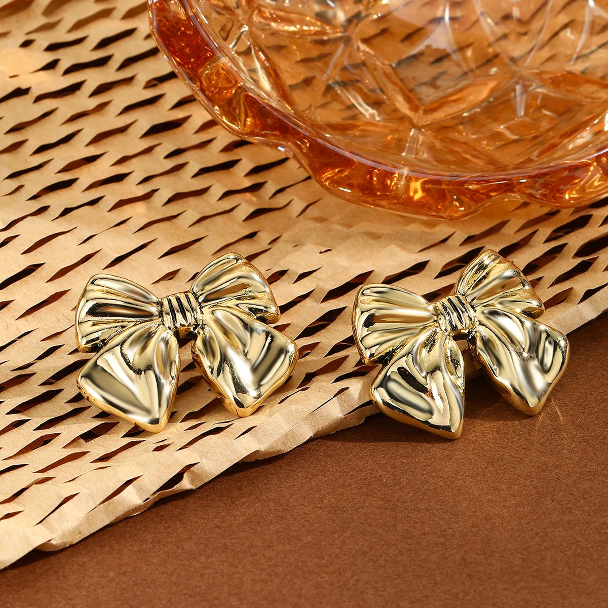 Boucles d’oreilles Lysimache dorées, accessoire tendance au design noué volumineux, idéal pour un look affirmé.
