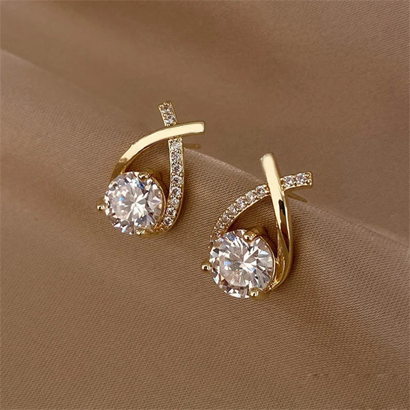 Détail des boucles d’oreilles Chrysaor dorées, design élégant avec un ornement central brillant pour un éclat maximal.