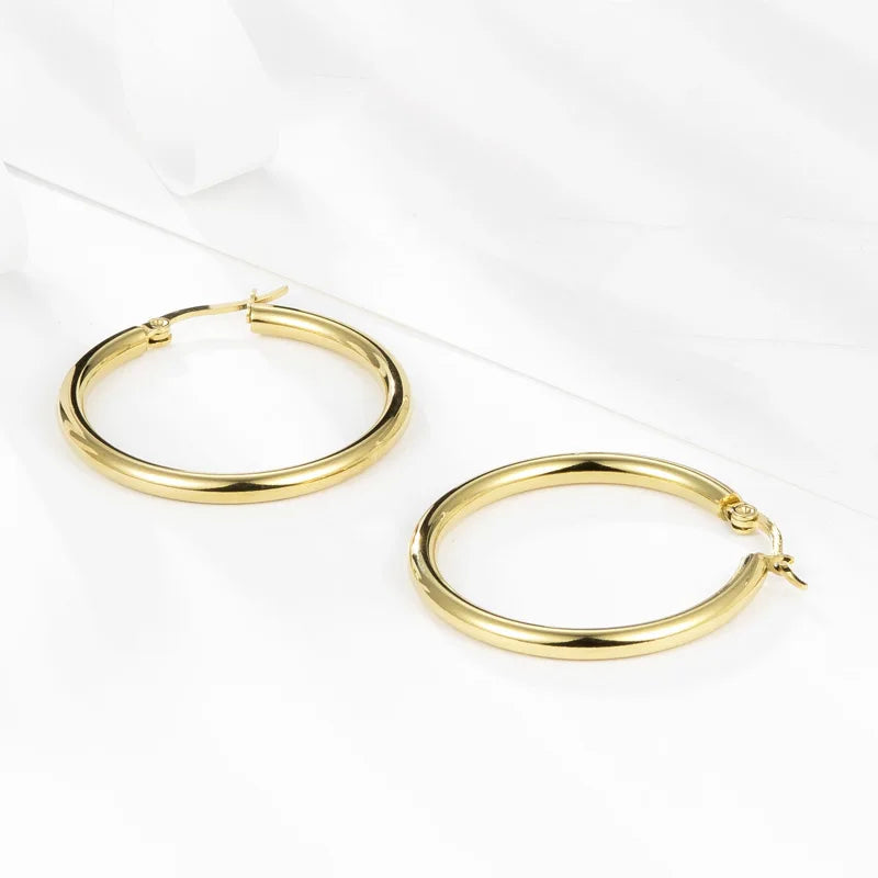 Boucles d’oreilles créoles épaisses dorées en acier inoxydable – bijou féminin à la finition lisse et brillante.