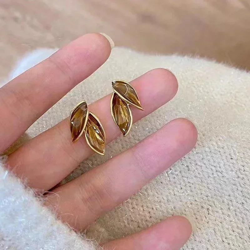 Boucles d’oreilles Thalassa dorées, design feuille délicat avec un subtil effet nacré, bijoux raffinés et intemporels.