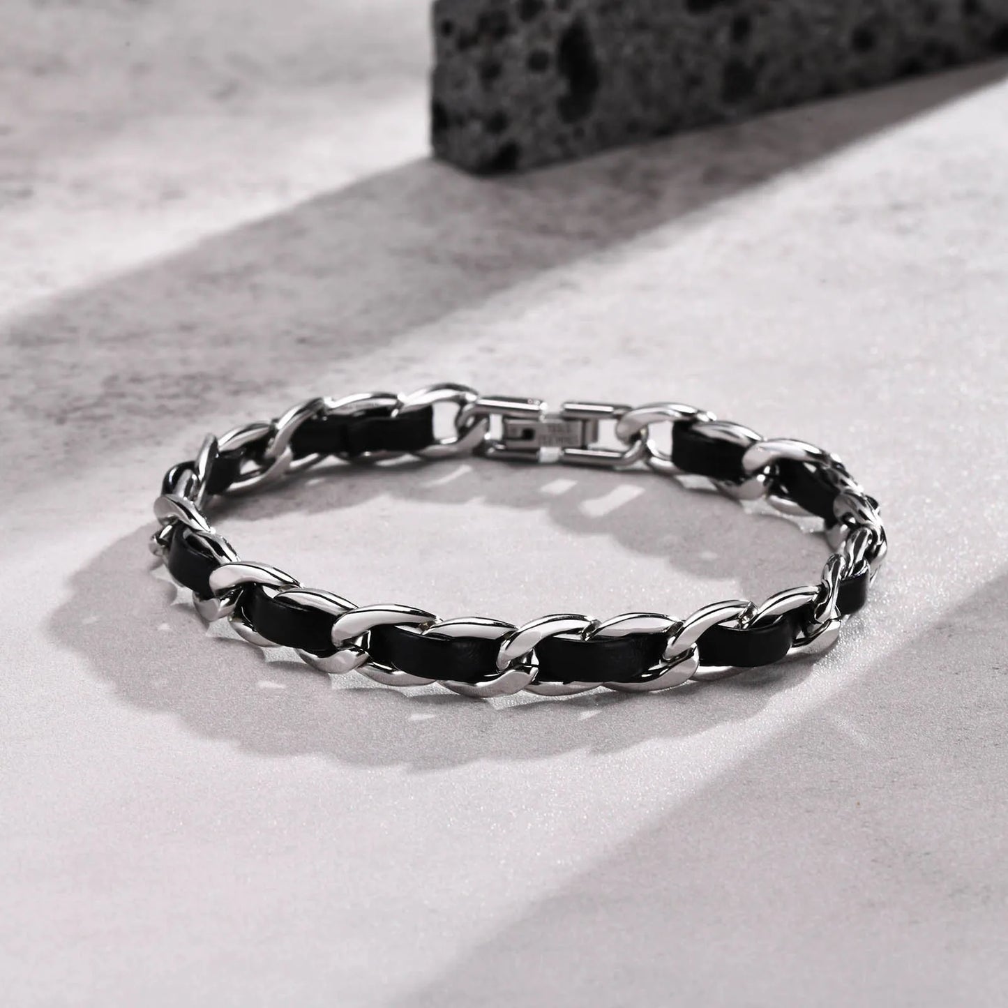 Bracelet Éole en acier inoxydable et cuir noir, contraste élégant entre modernité et authenticité.
