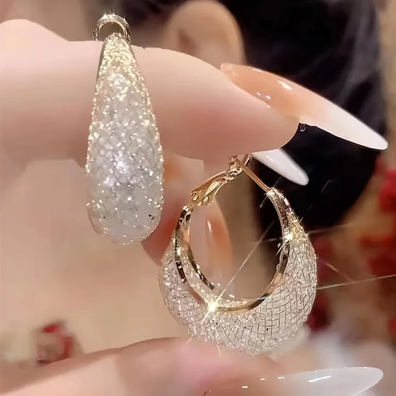 Boucles d’oreilles Laodicé dorées, créoles modernes en acier inoxydable avec strass brillants pour un éclat subtil et sophistiqué.