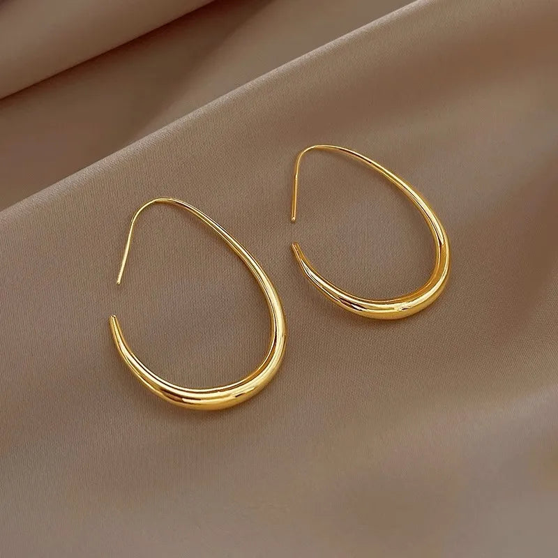 Boucles d’oreilles Erato dorées en acier inoxydable, créoles ovales minimalistes, parfaites pour un look chic et sophistiqué.