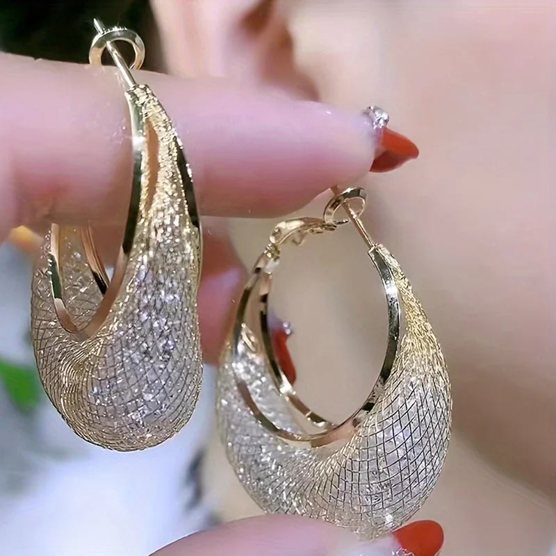 Boucles d’oreilles Laodicé dorées, détails raffinés de strass sur une créole fine en acier inoxydable, bijou éclatant et intemporel.
