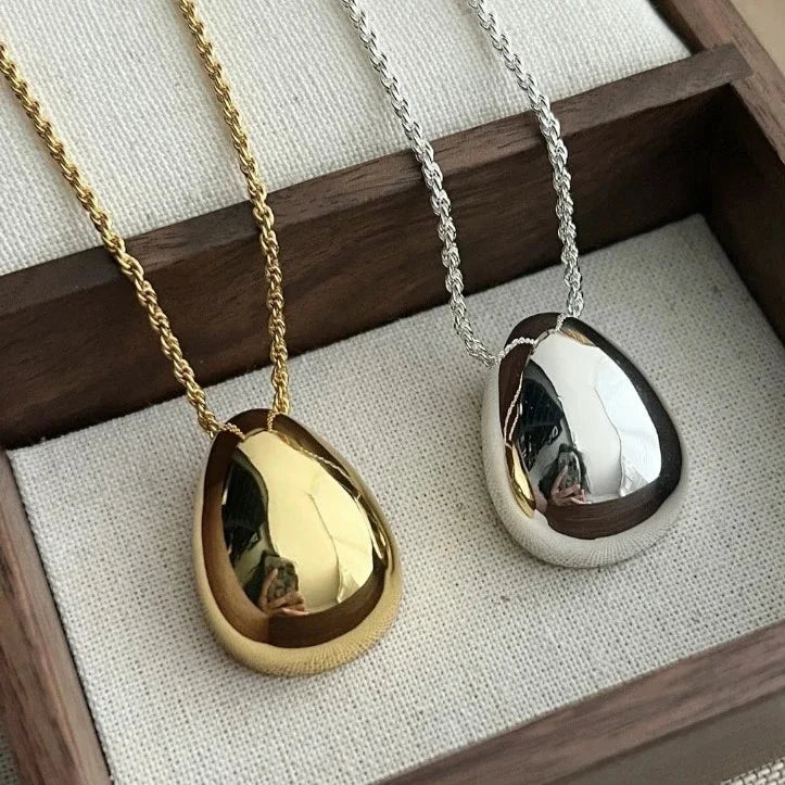 Collier femme Hélène en acier inoxydable doré et argenté, accessoire minimaliste et raffiné au pendentif épuré.