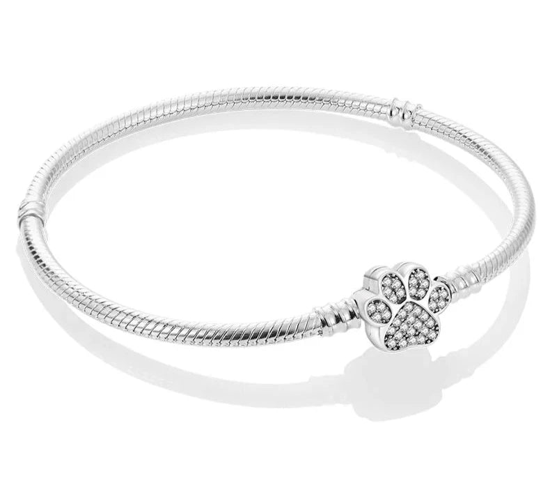 Bracelet femme Force de Nature en acier inoxydable argenté, bijou élégant avec une maille serpent fluide et un pendentif patte d’ours scintillant.