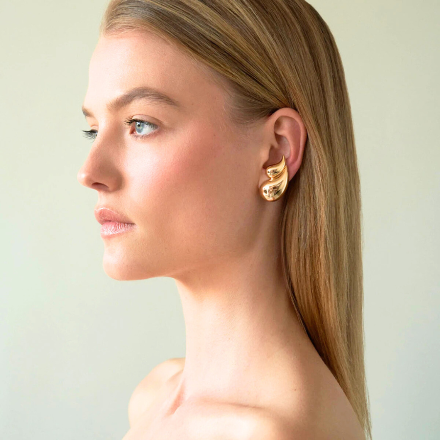 Boucles d’oreilles Aglaia dorées, accessoire chic et féminin, captant la lumière avec subtilité.