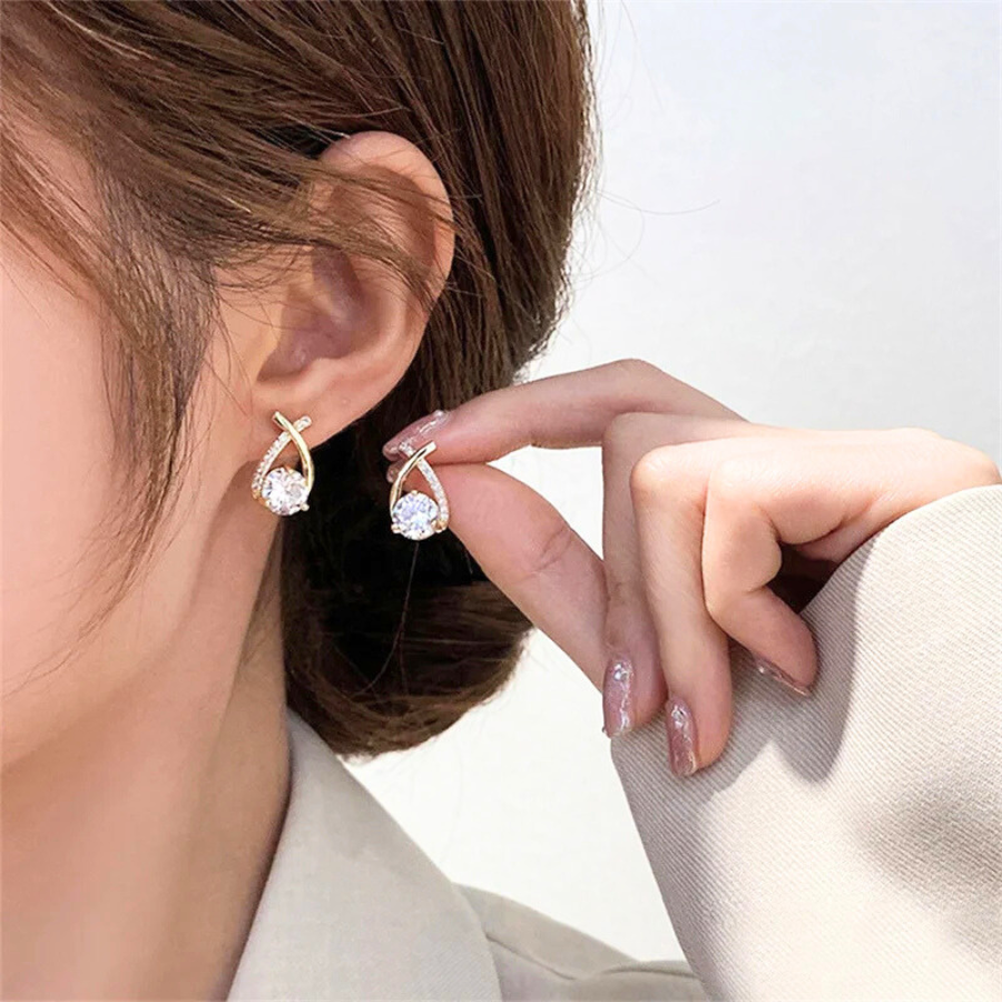Boucles d’oreilles Chrysaor en acier inoxydable doré, design moderne avec ornement scintillant, accessoire raffiné et élégant.