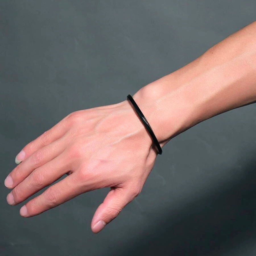 Bracelet jonc Perséus noir en acier inoxydable, bijou audacieux et structuré, porté pour un look sophistiqué.