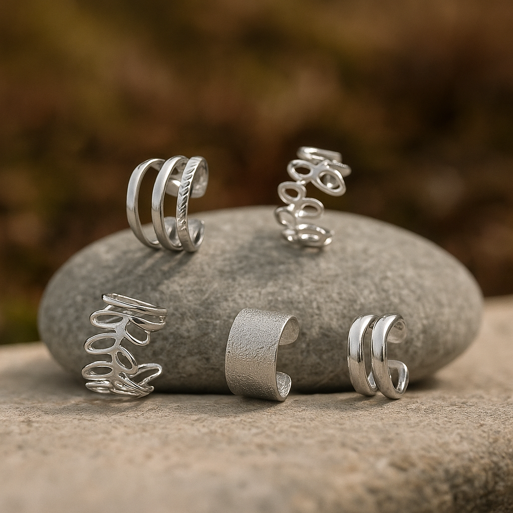 Coffret de 5 earcuffs argentés en acier inoxydable chirurgical posés sur une pierre, bijoux sans perçage L’Écrin d’Éclat.