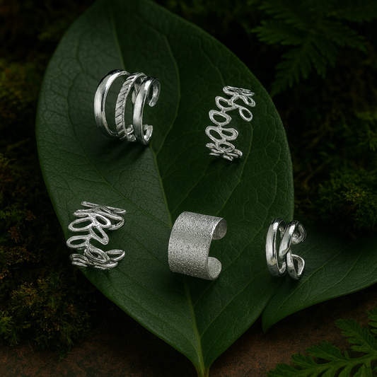 earcuff argenté sans perçage posé sur fond nature chic avec feuillage vert, bague d’oreille élégante L’Écrin d’Éclat