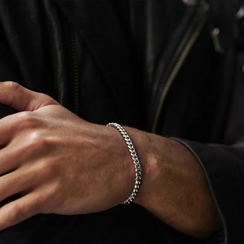 Bracelet homme Achilles en acier inoxydable argenté, avec maille gourmette fine de 5 mm, porté pour un look élégant et intemporel.