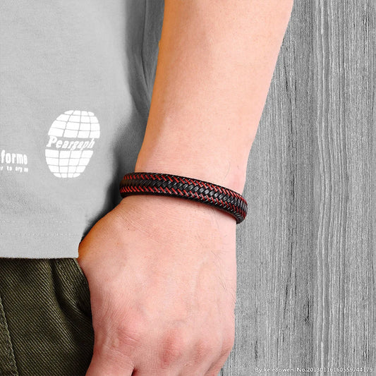 Bracelet homme Léonidas en cuir tressé noir avec surpiqûre rouge, porté pour un style dynamique et raffiné.