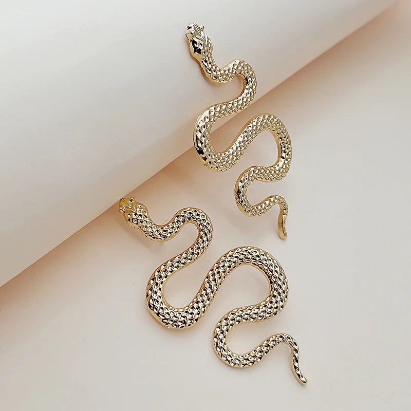 Boucles d’oreilles Callidora dorées en acier inoxydable, design serpent stylisé et élégant, accessoire sophistiqué et unique.