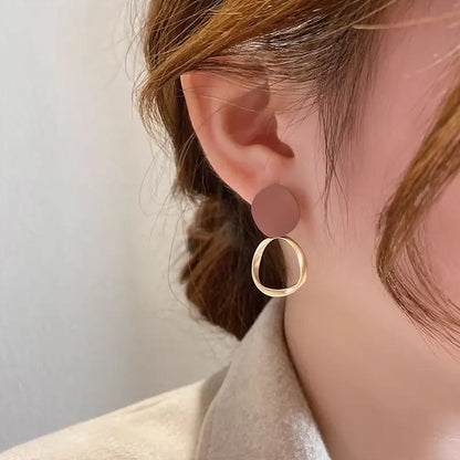 Boucles d’oreilles Théia en acier inoxydable doré avec détail marron profond, design pendants raffinés et élégants.