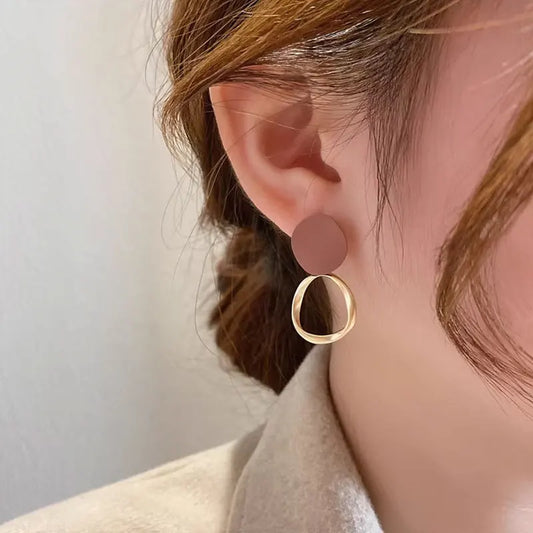 Boucles d’oreilles Théia en acier inoxydable doré avec détail marron profond, design pendants raffinés et élégants.