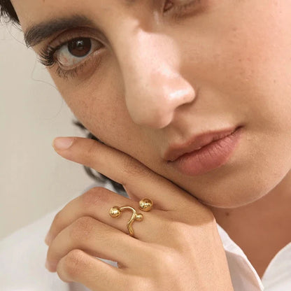 Bague femme Séléné en acier inoxydable doré, bijou ajustable raffiné avec trois perles délicates, portée pour un style sophistiqué et moderne.