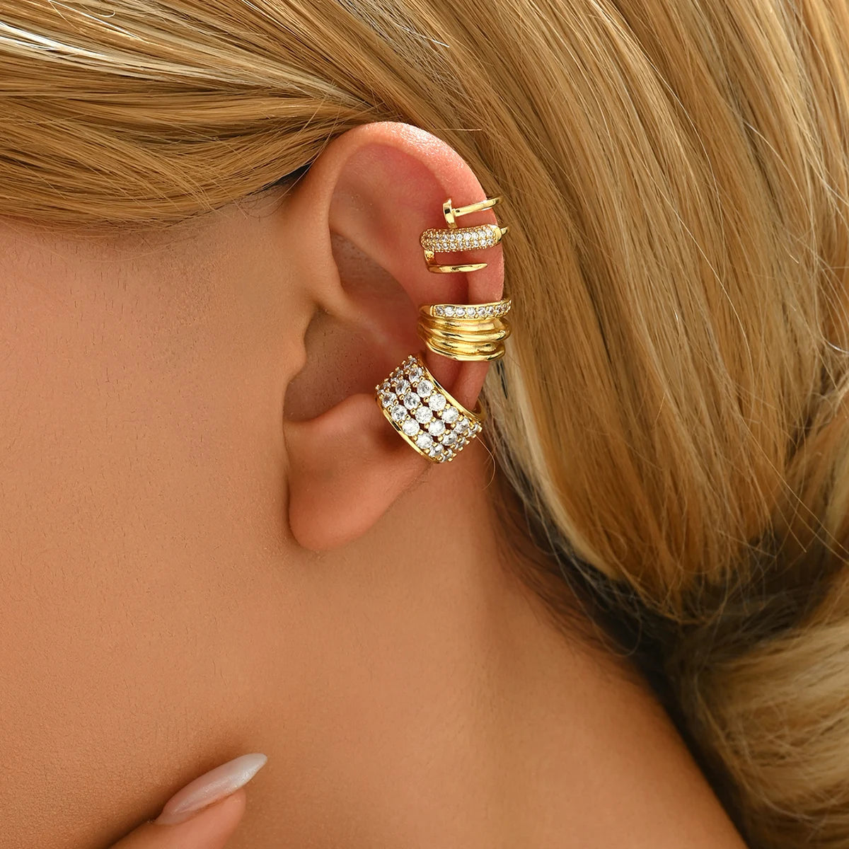 Lot de 3 boucles d’oreilles ear cuff dorées en acier inoxydable porté par une femme – élégance moderne et scintillante.
