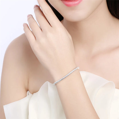 Bracelet femme Éclat Éternel en acier inoxydable argenté, bijou raffiné avec maille serpent fluide, porté pour un style élégant et intemporel.
