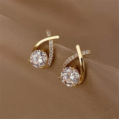 Détail des boucles d’oreilles Chrysaor dorées, design élégant avec un ornement central brillant pour un éclat maximal.