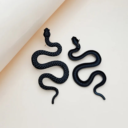 Boucles d’oreilles Callidora noires en acier inoxydable, design serpent audacieux et mystérieux, bijou statement pour un look puissant.