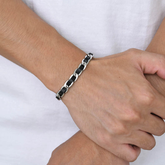 Bracelet homme Éole en acier inoxydable argenté et cuir noir tressé, porté pour un style élégant et masculin.