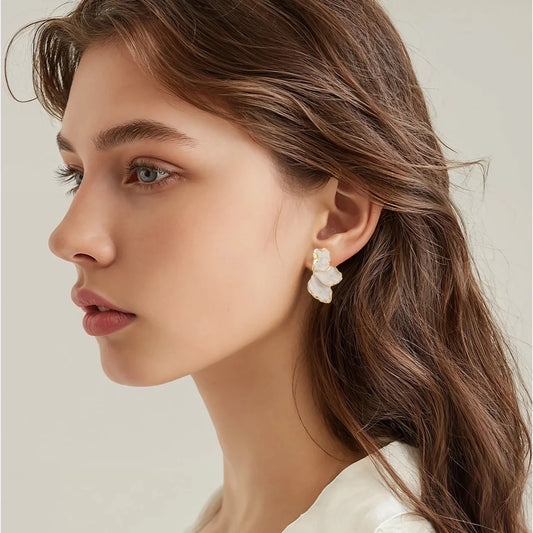 Boucles d’oreilles Mélibée en acier inoxydable doré, design demi-fleur élégant avec pétales nacrés, bijou raffiné et lumineux.