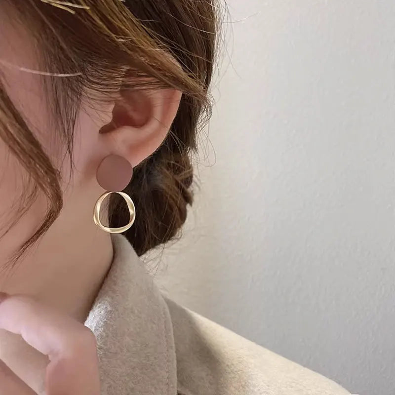 Boucles d’oreilles Théia pendantes dorées avec anneau fin et touche marron, parfaites pour un look sophistiqué et moderne.