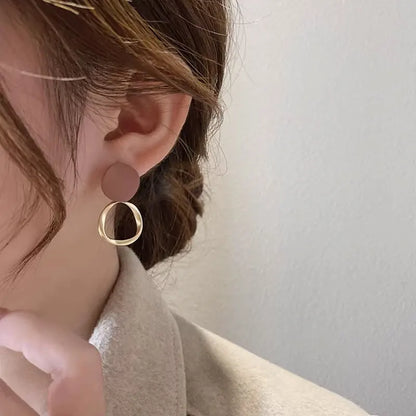 Boucles d’oreilles Théia pendantes dorées avec anneau fin et touche marron, parfaites pour un look sophistiqué et moderne.