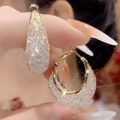 Boucles d’oreilles Laodicé dorées, créoles modernes en acier inoxydable avec strass brillants pour un éclat subtil et sophistiqué.