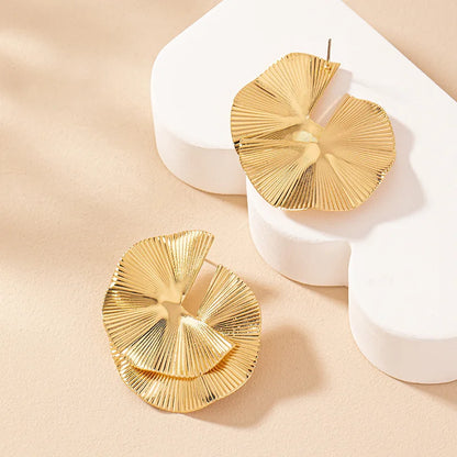 Boucles d’oreilles Mnémé dorées, accessoire sculptural et raffiné, idéal pour une touche contemporaine et artistique.