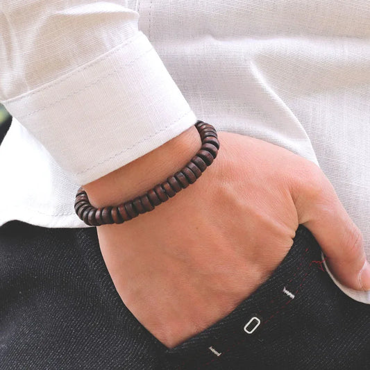 Bracelet homme Éthos en perles de bois marron, bijou naturel et élégant porté pour un style authentique et raffiné.