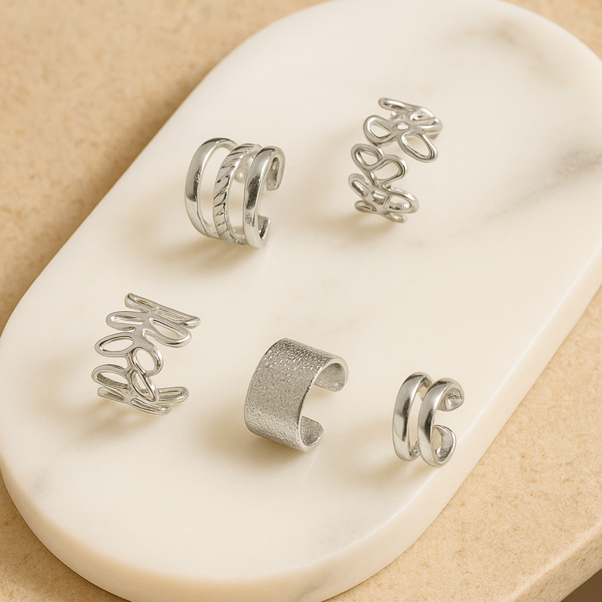Coffret de 5 earcuffs argentés – boucles d’oreilles sans perçage élégantes en acier inoxydable posées sur marbre chic