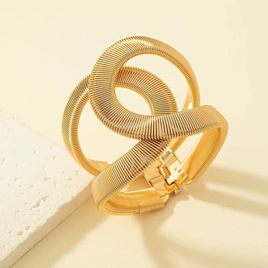 Bracelet Phaedra doré en acier inoxydable, revisitant le jonc classique avec une maille serpent fluide et sophistiquée.