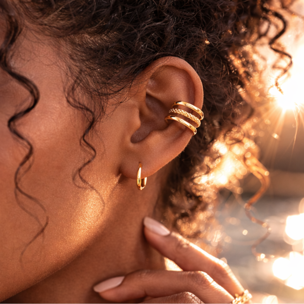 Paire d'ear cuffs Trio Harmonie dorés sans perçage portés sur l'oreille