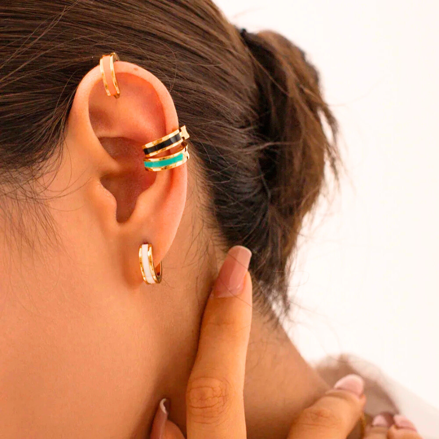 Boucles d’oreilles Callisto en acier inoxydable doré, avec insert coloré noir, blanc et vert, portées avec élégance.