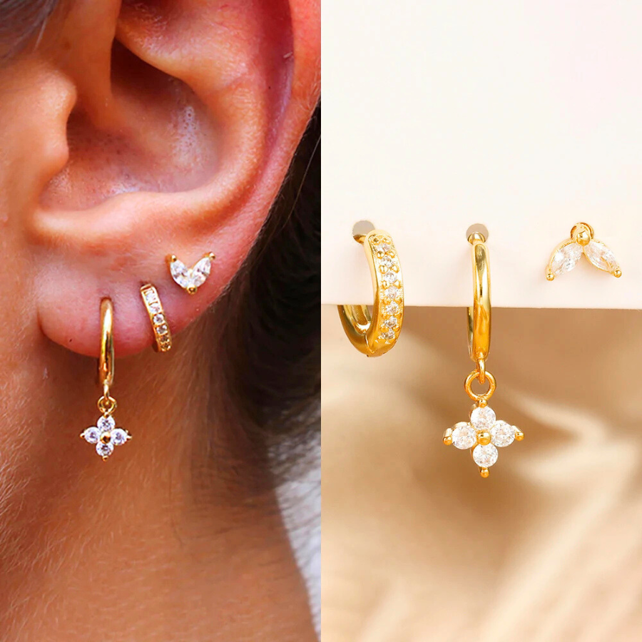 Boucles d’oreilles Cléophée en acier inoxydable doré avec strass blancs étincelants, portées avec style.