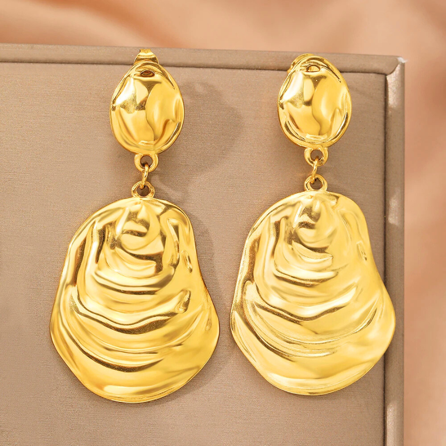 Boucles d’oreilles Andromaque dorées, bijou raffiné aux lignes ondulées, idéal pour un look moderne et sophistiqué.