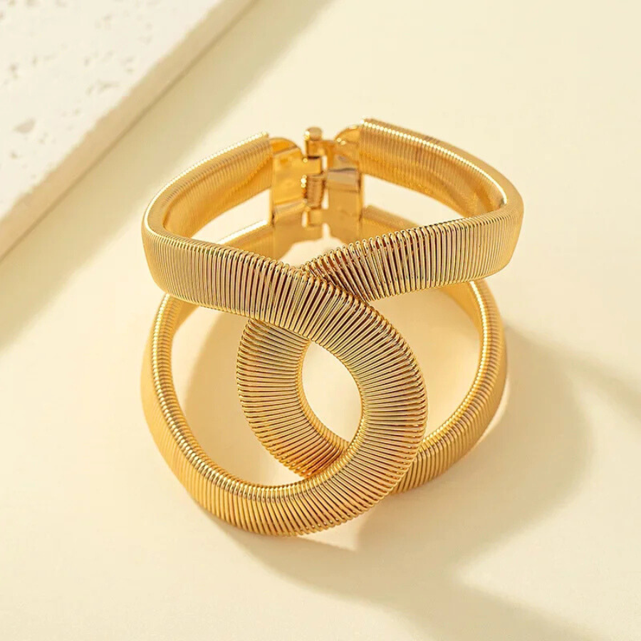 Bracelet Phaedra en maille serpent plate, bijou chic et intemporel en acier inoxydable doré, posé à plat pour une meilleure vue des détails.