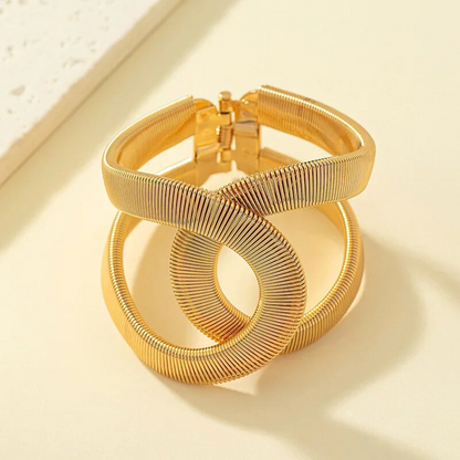 Bracelet Phaedra en maille serpent plate, bijou chic et intemporel en acier inoxydable doré, posé à plat pour une meilleure vue des détails.