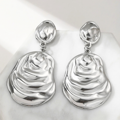 Boucles d’oreilles Andromaque argentées, bijou lumineux et tendance aux lignes fluides et harmonieuses.